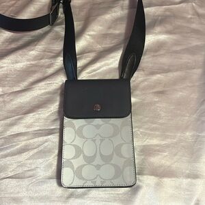 This is a small Coach crossbody bag. It is reflective and is unisex.